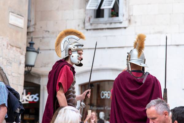 Actors dressed as Roman soldiers in a stone square in Split