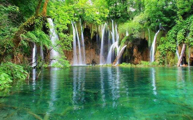 Waterfalls falling into a green lake in Plitvice Lakes National Park